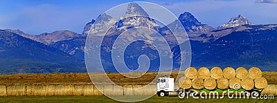 Truck Hauling Hay with Teton Mountains in Background Stock Photo