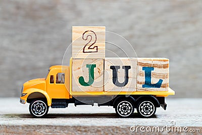 Truck hold block in word 2jul on wood background Concept for date 2 month July Stock Photo