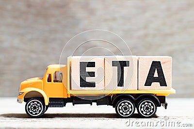 Truck hold block in word ETA abbreviation of estimated time of arrival on wood background Stock Photo