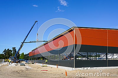 Truck mounted crane with a telescoping boom at constructing a metal carcas of a new building Stock Photo