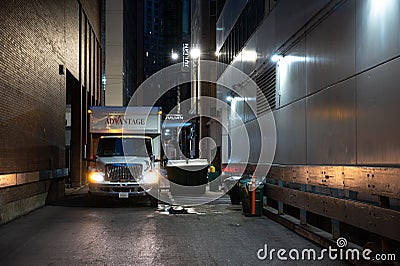 Truck parked in an illuminated, narrow alleyway in the evening Editorial Stock Photo