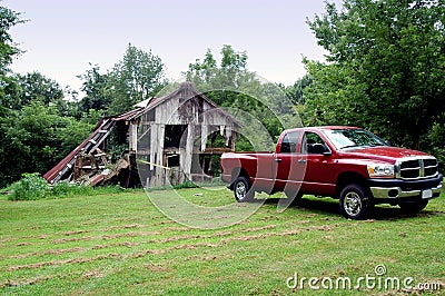 Truck pulling down old barn Stock Photo