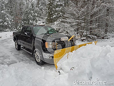 Truck snow plow clearing a parking lot after storm Stock Photo