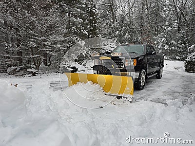 Truck snow plow clearing a parking lot after storm Stock Photo