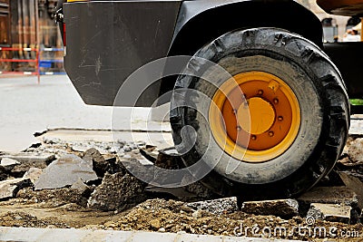 Truck tire on a broken asphalt at construction site in urban environment Stock Photo