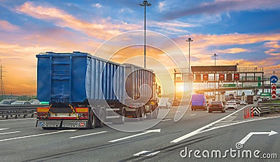 Truck transportation with separate trailer blue color drives among other cars heavy traffic along city highway during sunset sky Stock Photo