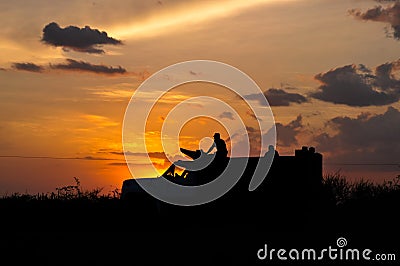 Truck used in the construction industry with workers in sunset light. Stock Photo