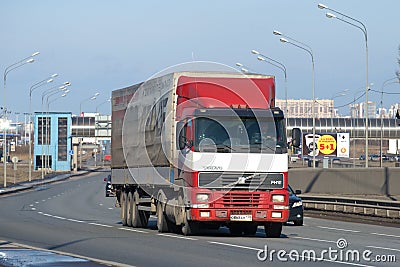 Truck Volvo FH12 with a tilted semitrailer on Pulkovskoe highway in the spring afternoon Editorial Stock Photo
