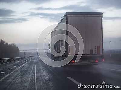 A truck wagon rides on a highway with poor visibility where it rains and fog, background. Bad Road Safety Concept, copy Stock Photo