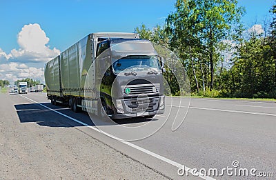 trucks goes on highway in evening Stock Photo