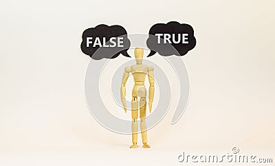 True or false symbol. Wooden model of businessman human. Black paper with words `true false`. Beautiful white background, copy Stock Photo