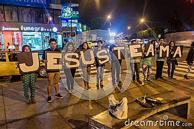 TRUJILLO, PERU - JUNE 6, 2015: Group of local youngsters shows text Jesus te ama. It means Jesus loves yo Editorial Stock Photo