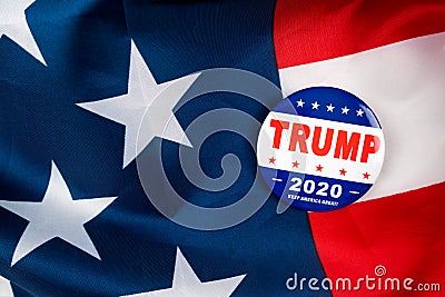 Trump presidential election campaign 2020 vote button; pin laying on the american flag.trump presidential election campaign 2020 v Editorial Stock Photo