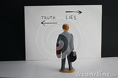 Truth and lies choice concept with miniature man decides about his way Stock Photo