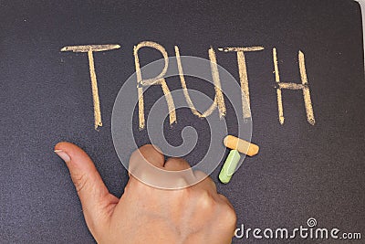 TRUTH written in chalk on blackboard and hand showing thump up Stock Photo