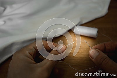 Try to thread the thread in the needle Stock Photo