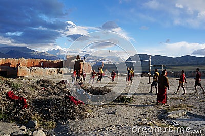 Nepal. Tsarang. Gompa novices play volleyball during the rest, behind the monastery, against the backdrop of the Himalayas. Editorial Stock Photo
