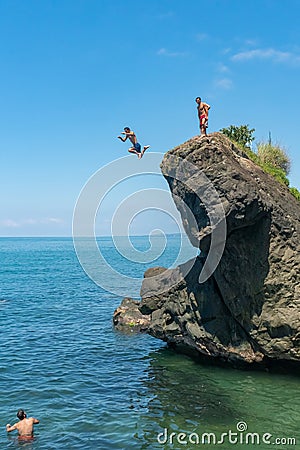 Tsikhisdziri, Georgia - 07 August, 2020: Man jumping from high rock to the see Editorial Stock Photo
