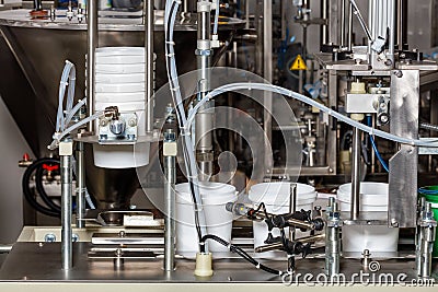 Food industry equipment, an automatic machine for filling products into plastic buckets Stock Photo