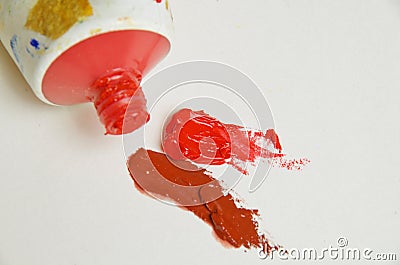 Tube of cadmium red oil paint with blobs of red and brown paint Stock Photo