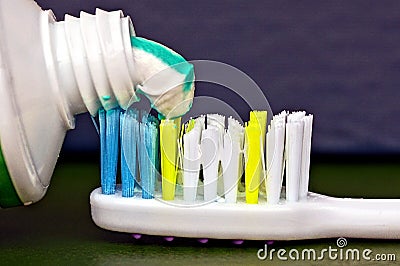 Tube with colored toothpaste and part of toothbrush Stock Photo