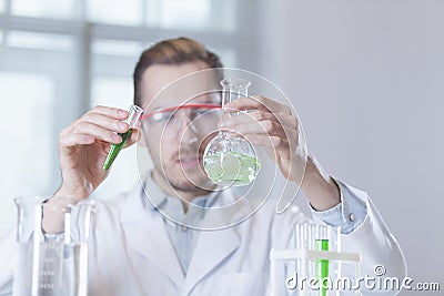 The tube and flask in the hands of the scientist Stock Photo