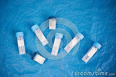 tube for sampling biological material on a blue background, top view Stock Photo