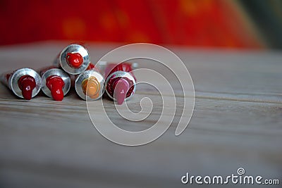 Tubes close-up with bright multi-colored watercolors red shades. Good background for art publications Stock Photo