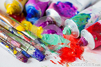 Tubes of multicolor oil paint and artist paintbrushes on canvas Stock Photo