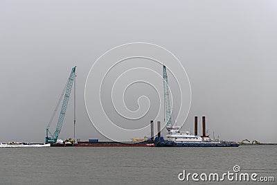 Tug moored to bardge. Construction Marine offshore works. Dam building, crane, barge, dredger Stock Photo