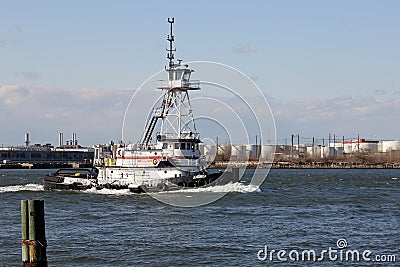 Tugboat ANDREA passing Kill Van Kull strait eastward on background of Bayonne, NJ Editorial Stock Photo