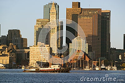 Tugboat with Boston Harbor and the Boston skyline at sunrise as seen from South Boston, Massachusetts, New England Editorial Stock Photo