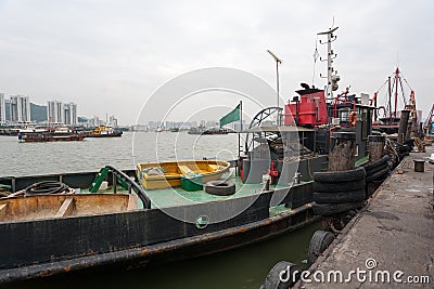 Tugboat and fishing vessels are at berth in the port of Macao. Stock Photo