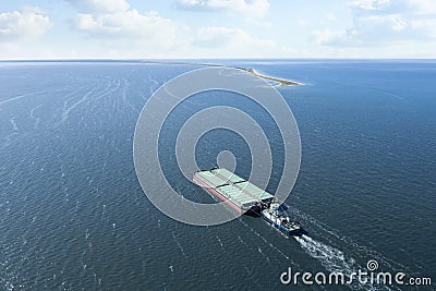 Tugboat pulling barge with cargo by water, aerial view Stock Photo