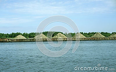 Tugboat pushes sand debris along the river Stock Photo