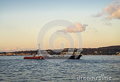 Tugboat is pushing another vessel on the sea Stock Photo