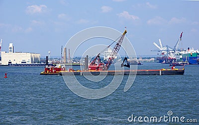 Tugboat pushing dredging barge Stock Photo