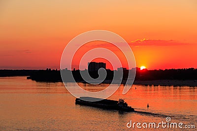 Tugboat pushing heavy long barge on the river Dnieper at sunset Editorial Stock Photo