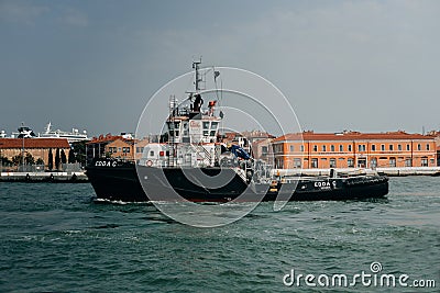 Tugboat sails off the coast of Venice Editorial Stock Photo