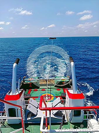 Tugboat towing the barge in the ocean Stock Photo