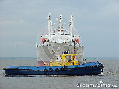 Tugboat towing a ship. Stock Photo