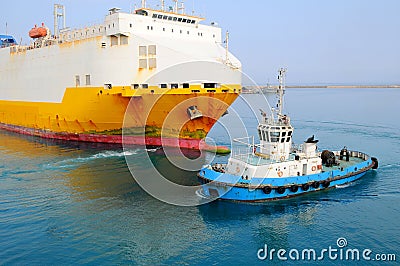 Tugboat towing a ship Stock Photo