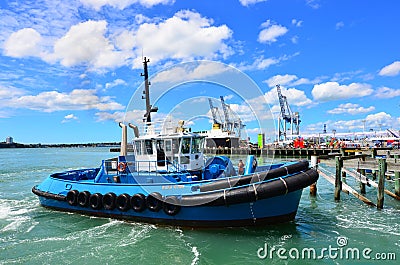 Tugboat works at Captain Cook Wharf in Ports of Auckland Editorial Stock Photo