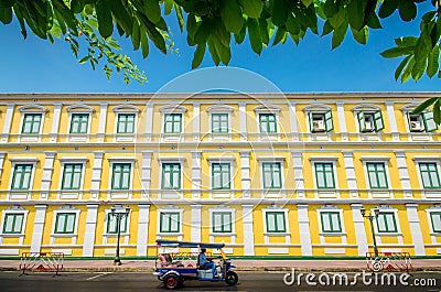 Tuktuk taxi in front of yellow building Stock Photo