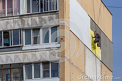 TULA, RUSSIA - OCTOBER 10, 2020: Industrial climber worker applying additional styrofoam insulation on outside wall of Editorial Stock Photo