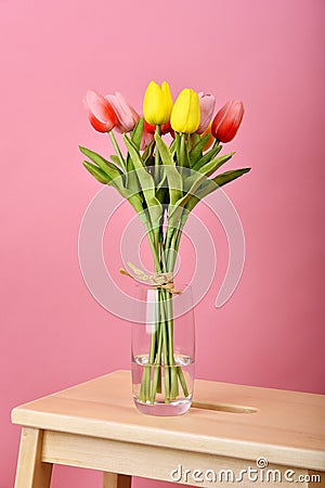 Tulip flowers bouquet for celebration on pink background. Artificial tulips arrangement in vase Stock Photo