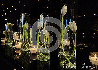 Tulip flowers decoration with candles at night, indoor luxury wedding with low light romantic ambient Stock Photo