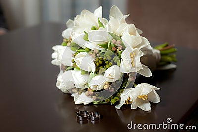 Tulip wedding bouquet with rings on table Stock Photo