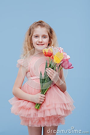Tulips. little girl with spring flowers in her hand, in pink dress Stock Photo