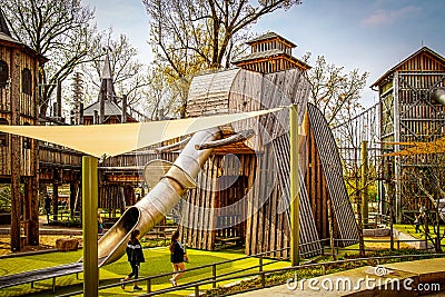 Wooden Elephant Climbing castle with slide for trunk and sail awning with children playing in Springtime Editorial Stock Photo